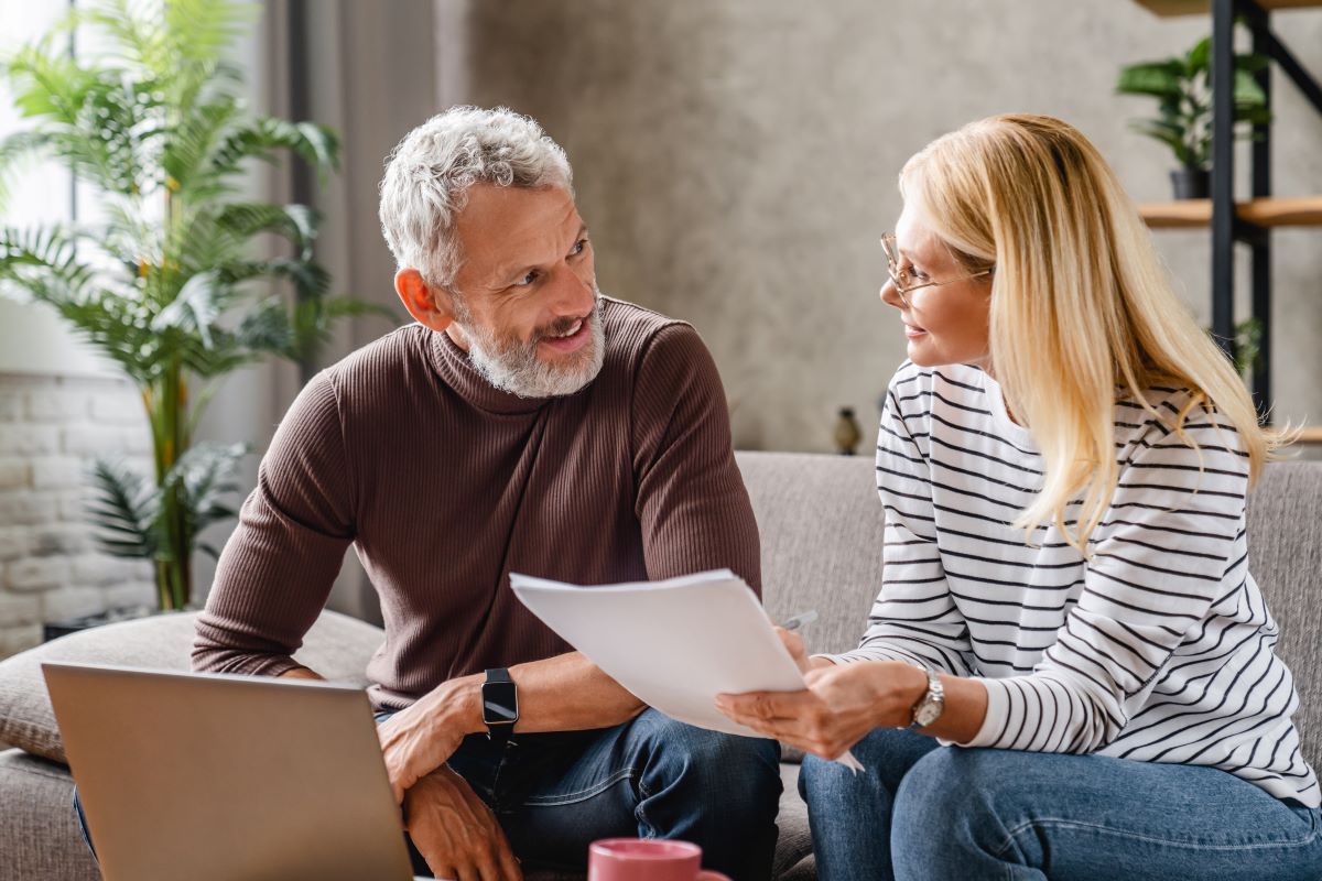 Couple reviewing documents sitting on a couch