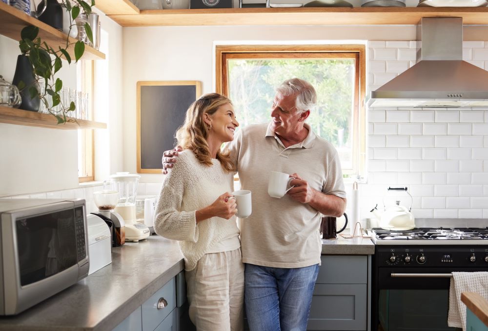 Senior couple drinking coffee at their kitchen